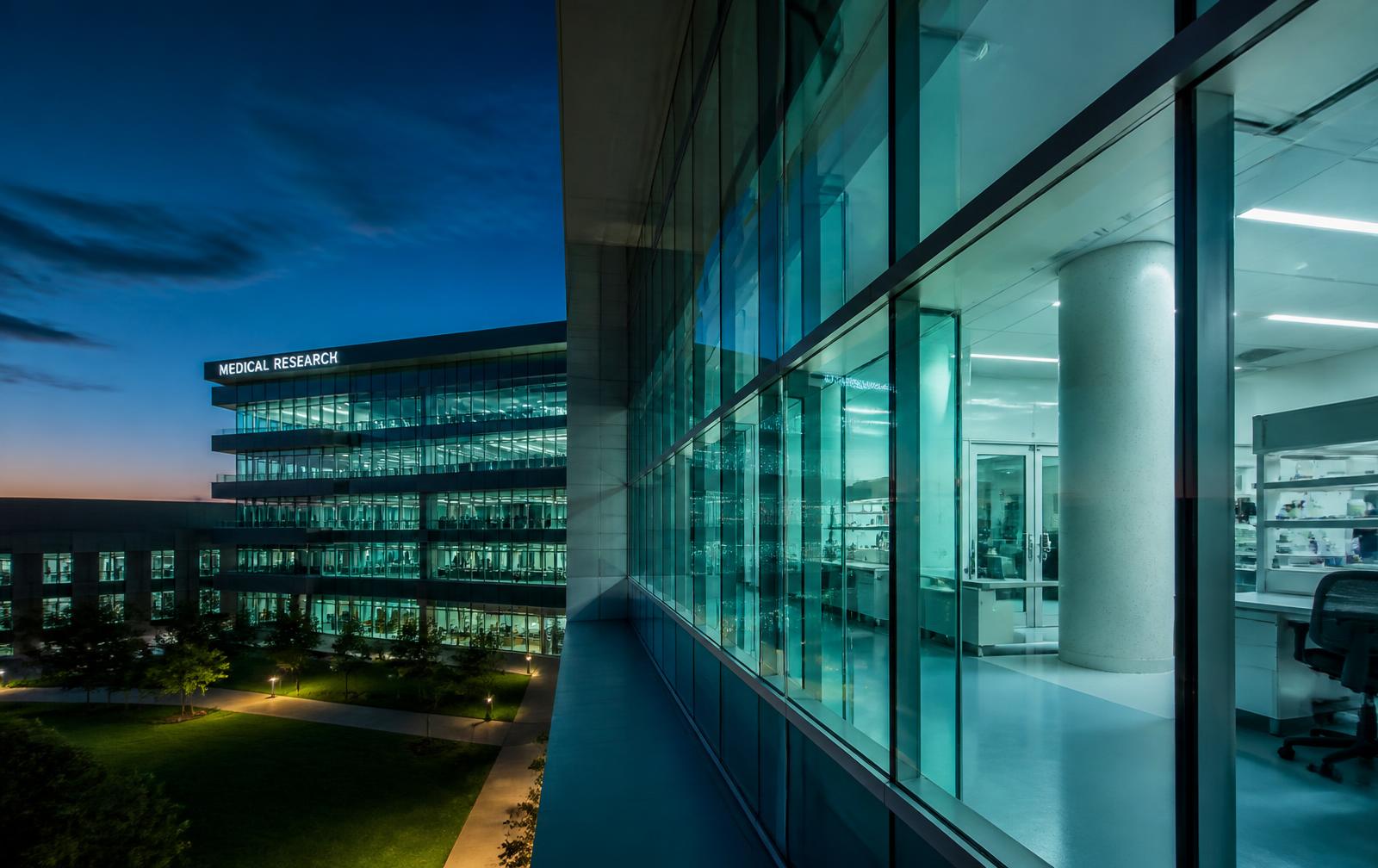 Modern hospital research building illuminated at dusk